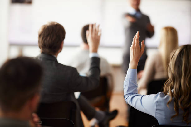 istock Rear view of entrepreneurs asking a question on presentation in the office. 1484339559