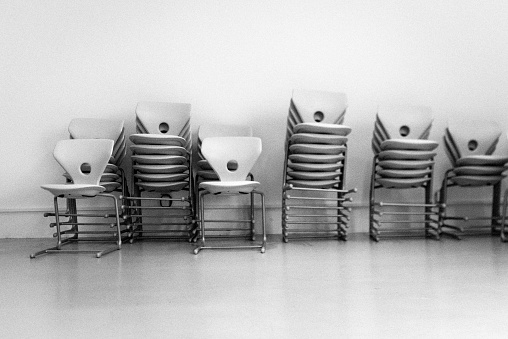 Stack of chairs in front of a white wall