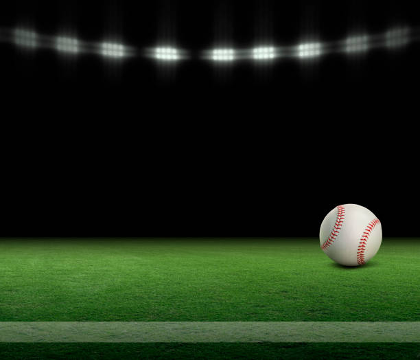 piłka baseballowa na trawiastym boisku z paskiem i czarnym tłem pod światłami - baseballowa rękawiczka zdjęcia i obrazy z banku zdjęć