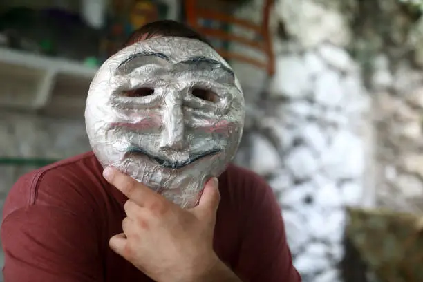 Portrait of person in anonymous mask in backyard