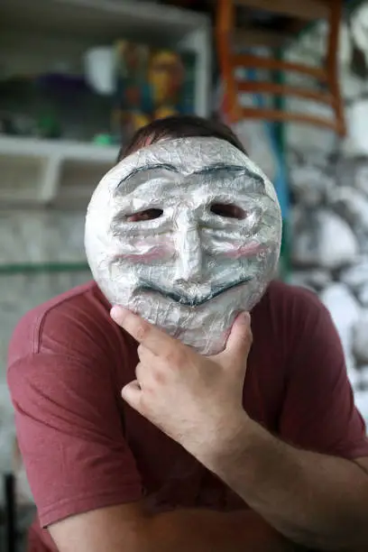 Portrait of man in anonymous mask in backyard