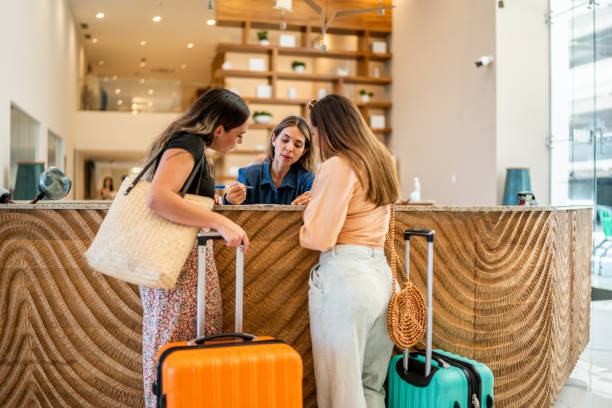 Receptionist talking customers at hotel lobby Hotel receptionist talking customers at lobby receptionist stock pictures, royalty-free photos & images