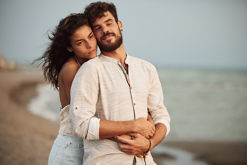 Young romantic couple enjoying in their love on the beach. Copy space.