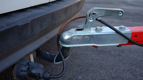 Trailer connected to car. Trailer on car's hook. Car hitch. Car delivering trailer.