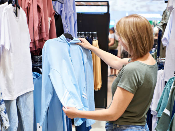 istock Woman chooses sweatshirt in store 1484368041