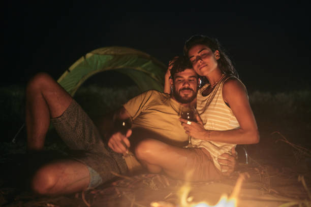 istock Loving couple drinking wine on camping night at the beach. 1484369092