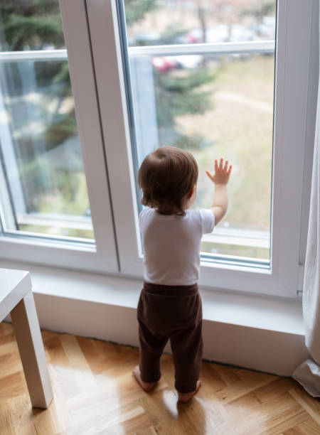 istock One year old child looking trough the window 1484375993