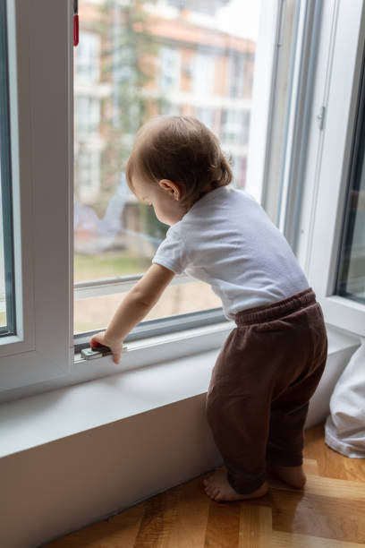 istock One year old child looking trough the window 1484389137