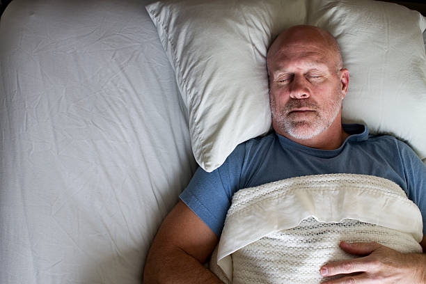 hombre durmiendo en la cama - one mature man only fotografías e imágenes de stock
