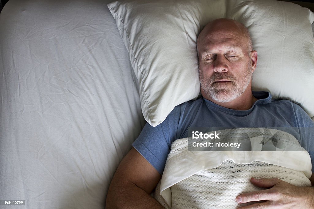 Man Sleeping in Bed Overhead photo of a man sleeping in a bed. Sleeping Stock Photo