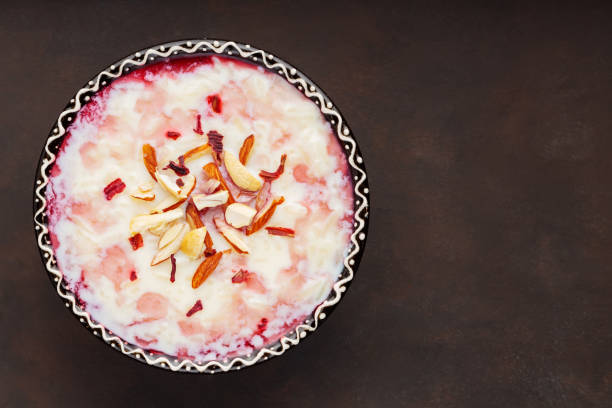 istock Indian kheer rice pudding with nuts on dark background. Delicious rice pudding with rose water. Copy space. Top view 1484418208
