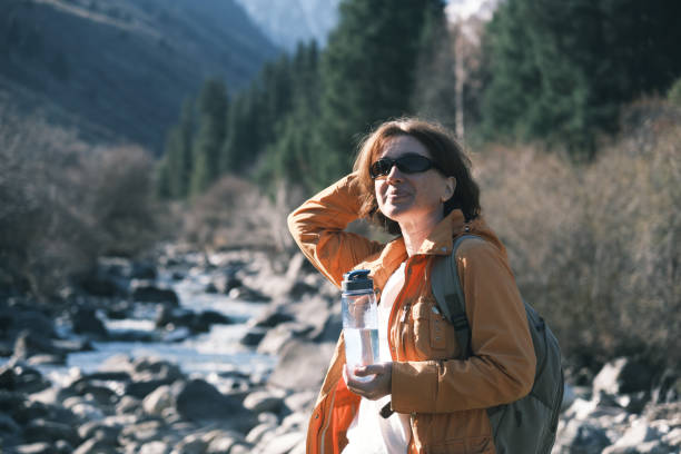 istock Female mountain hiker is drinking water 1484423065