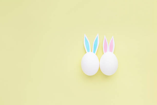 istock Easter eggs with handmade paper ears on yellow background. Nature concept. 1484423750