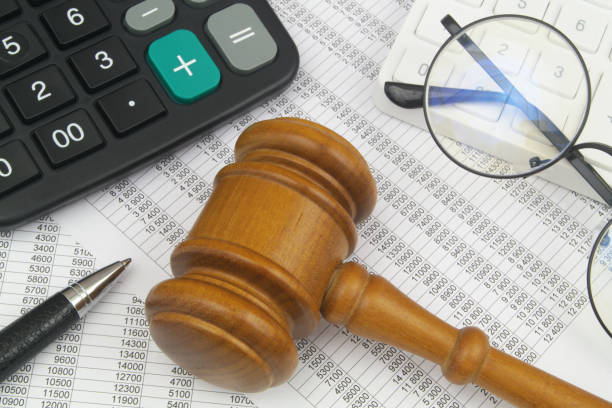 istock Glasses, calculators, pen and judge gavel on financial documents. 1484427111
