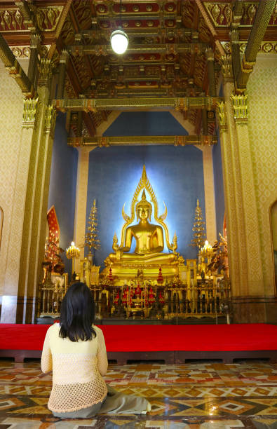 visitatrice che esprime un desiderio nella sala delle ordinazioni di wat benchamabophit (il tempio di marmo), bangkok, thailandia - old senior adult buddhism art foto e immagini stock