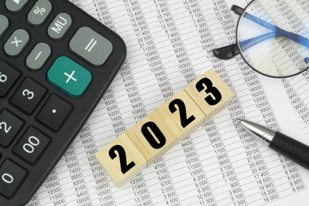 istock Numbers 2023 on cubes, calculator, pen and eyeglasses on documents. 1484427203