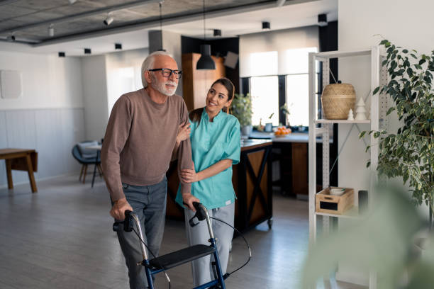 istock Caring nurse assisting elderly male patient to walk step by step with mobility walker 1484427935