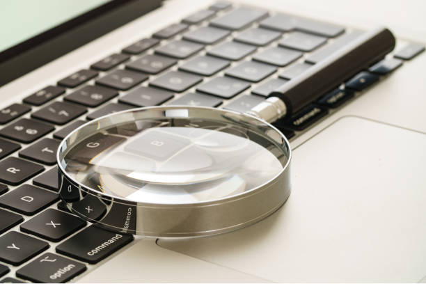 magnifying glass on computer keyboard - faq connection computer keyboard learning imagens e fotografias de stock