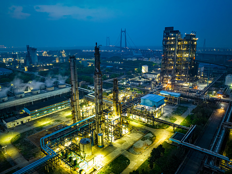 Aerial view of chemical refinery and building material glowing light at night