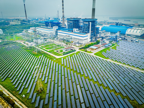 Aerial view of solar panels farm field near factory