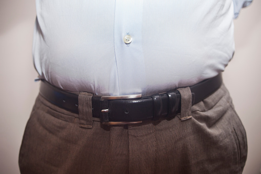 Man with a tight belt close-up view, overweight