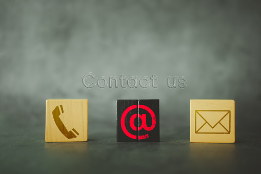 Contact us concept. Wooden blocks with telephone, address, and email icons.Website page contact us or e-mail marketing. Customer service and contact us concept