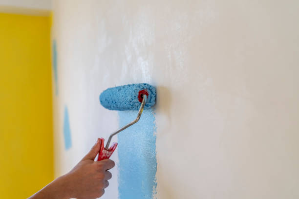 istock Workman painting the wall in blue. 1484459834