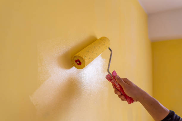 istock Workman painting the wall in yellow. 1484460455