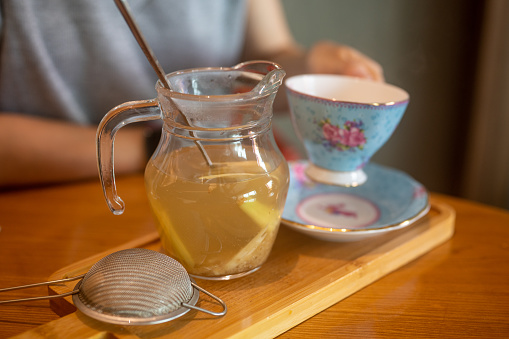 Inage on full serving of linden tea, lemon and a cup with copy space over wooden table background