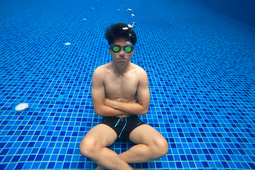 Portrait of an Asian young adult in underwater swimming pool