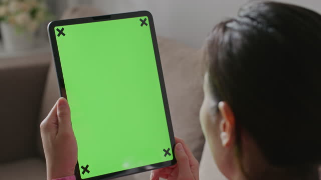 Shoulder of Woman Using Hand Gestures on Green Mock-up Screen Digital Tablet
