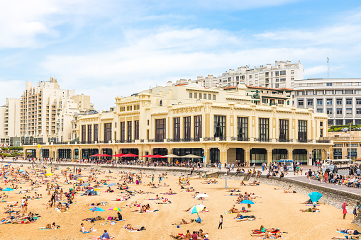 Casino Barriere building and Grande Plage beach of Biarritz with lots of people on a summer day, France