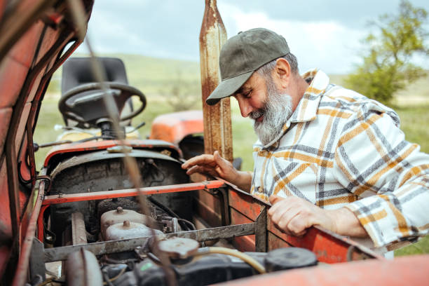 istock Farmer is repairing a tractor in the field 1484481115