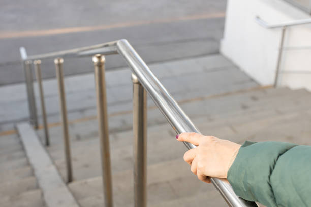 istock woman holding on to the railing going down the stairs. 1484481345