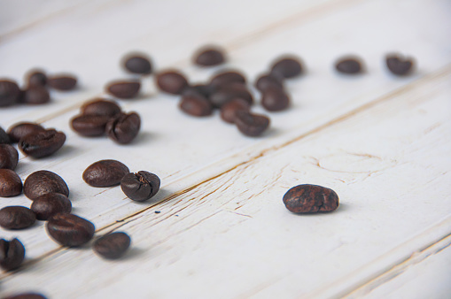 Scattered coffee beans on wooden cover background with customizable space for text or coffee ideas