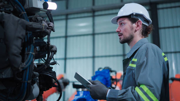 istock Professional industrial engineer, technician, factory worker wear hard hat safety. While set up, control machine heavy industry factory. Employee working in manufacturing facility 1484484222