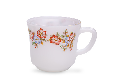 Beautiful empty white glass tea cup with colorful floral pattern isolated on white background with clipping path.