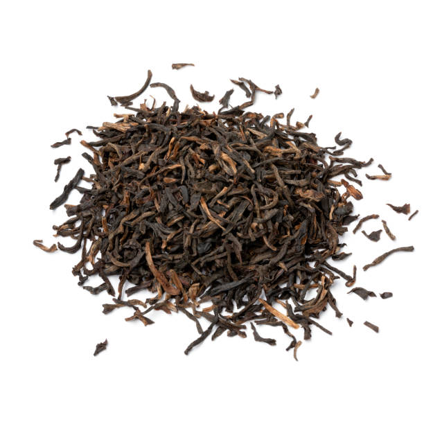 Heap of Indian Assam black Harmutty dried tea leaves close up on white background stock photo