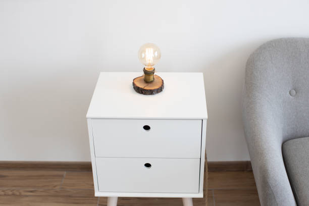 istock Edison lamp on bedside table near sofa in studio room 1484514560