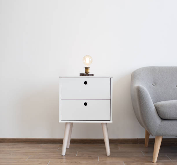 Edison lamp on bedside table near sofa in studio room