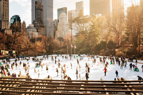 Central park of new york city during winter with several ice skaters High angle view of a central park of new york city during winter with several ice skaters. People doing ice skating in central park. ice rink stock pictures, royalty-free photos & images