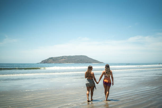 istock Lesbian couple taking a walk by the sea holding hands 1484525419