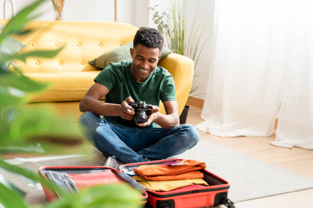 istock Cheerful black man packing for vacation 1484525924