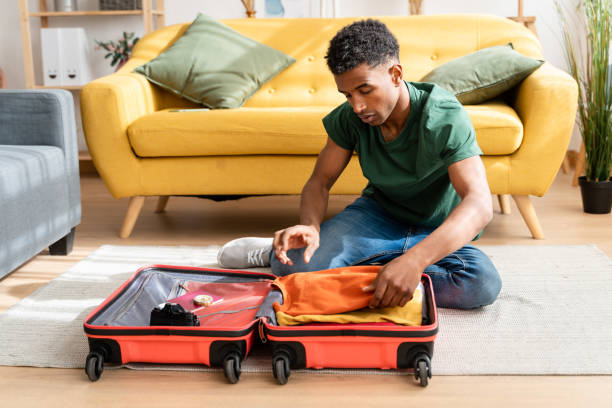 istock Cheerful black man packing for vacation 1484527275