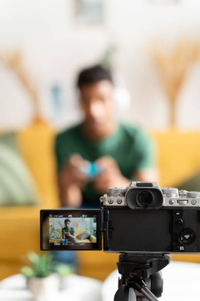 istock afro boy playing video games while filming for his video blog 1484540367