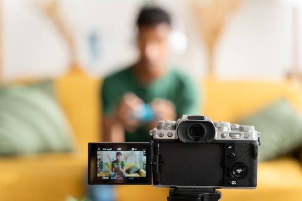 istock afro boy playing video games while filming for his video blog 1484541010