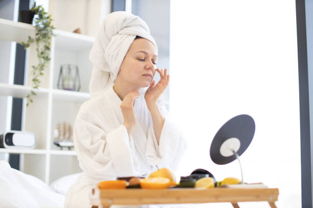 istock Woman putting patch under eye with help of mirror indoors 1484543405