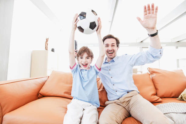 istock father and son wathcing football 1484545572