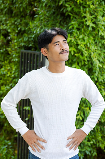 Looking up Young thai man with mustache outdoor portrait
