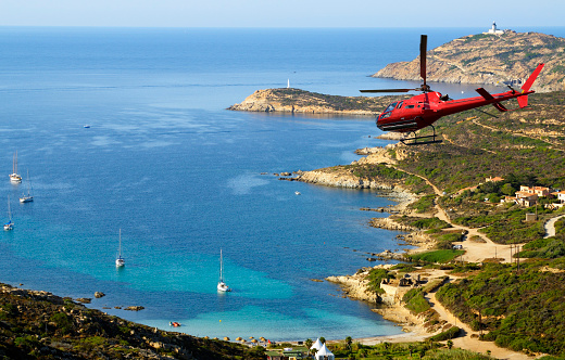 Helicopter flying over a gulf, Corsica, Europe.